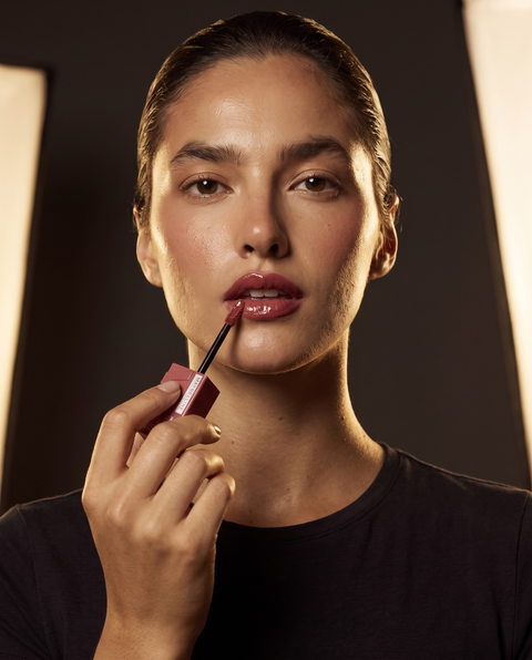 Maybelline Superstay Vinyl Ink Flüssiger Lippenstift, Model trägt glänzendes Rosenholz-Finish auf den Lippen